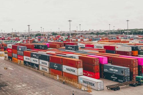Colorful shipping containers stacked at a bustling port showcasing global trade.